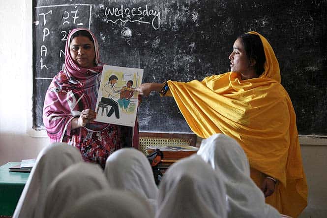 Teachers display a card with an illustration depicting a girl going through a medical checkup by a doctor during a class in an elementary school in Pakistan. (Reuters photo)
</div) Teachers display a card with an illustration depicting a girl going through a medical checkup by a doctor during a class in an elementary school in Pakistan. (Reuters photo)
</div)