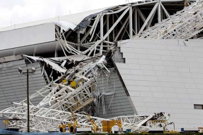 Workers stare at damages at the Arena de Sao Paulo stadium, still under construction, after a crane fell across part of the metallic structure. (AFP Photo) Workers stare at damages at the Arena de Sao Paulo stadium, still under construction, after a crane fell across part of the metallic structure. (AFP Photo)