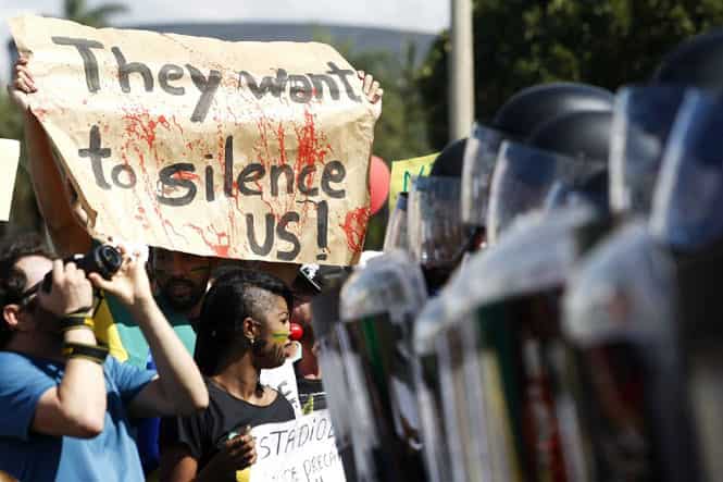 People gather near Brasilia's Estadio Nacional Mane Garrincha to protest against the allocation of funds towards the World Cup at a time when Brazil is in dire need of investment in other areas. (AFP Photo) People gather near Brasilia's Estadio Nacional Mane Garrincha to protest against the allocation of funds towards the World Cup at a time when Brazil is in dire need of investment in other areas. (AFP Photo)
