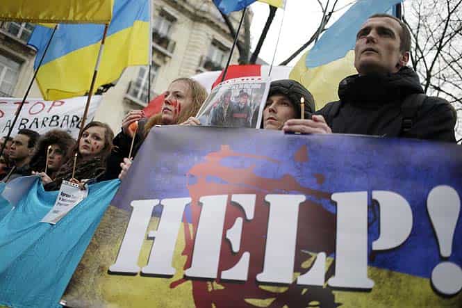 Demonstrators hold candles, placards and Ukranian flags in support of Ukranian protesters on February 20, 2014 in Paris. (AFP photo)</strong) Demonstrators hold candles, placards and Ukranian flags in support of Ukranian protesters on February 20, 2014 in Paris. (AFP photo)</strong)