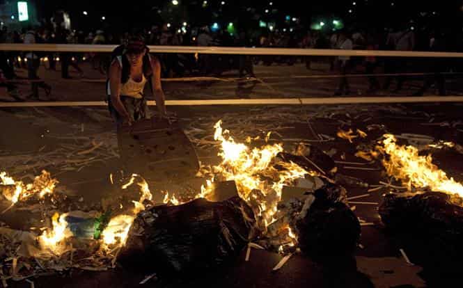 Venezuelan anti-government students light a fire during clashes with riot policemen following a protest in Caracas. (AFP photo)</strong) Venezuelan anti-government students light a fire during clashes with riot policemen following a protest in Caracas. (AFP photo)</strong)