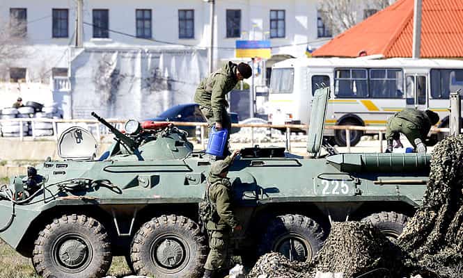 Armed men, believed to be Russian servicemen, supply an armoured personnel carrier (APC) in front of a Ukrainian marine base in the Crimean port city of Feodosia. (Reuters photo)
</div) Armed men, believed to be Russian servicemen, supply an armoured personnel carrier (APC) in front of a Ukrainian marine base in the Crimean port city of Feodosia. (Reuters photo)
</div)