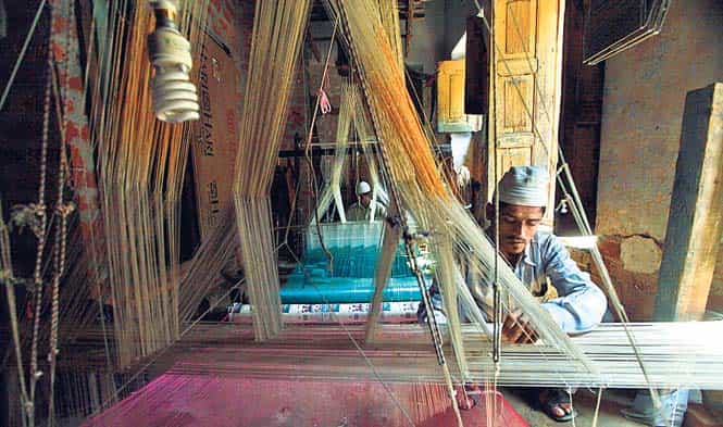 Mohammad Siraj, 40, is one of the weavers at Madanpura’s handloom industry. He works for 12-14 hours a day, which fetches him `100-150. Profit margins in the handloom industry are low because of the high cost of electricity and raw material. The promised loan waivers and subsidies never reached the area, he says. (Raj K Raj/HT photo)