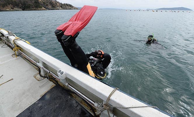 Yasuo Takamatsu jumps into the ice-cold sea water with a diving tank on the back from a boat in Onagawa, Miyagi Prefecture (AFP photo) Yasuo Takamatsu jumps into the ice-cold sea water with a diving tank on the back from a boat in Onagawa, Miyagi Prefecture (AFP photo)