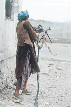An Afghan Uzbek fighter fires on Hizb-i-Islami forces of Gulbuddin Hekmatyar in April 1992 (Photo: Robert Nickelsberg) 
</div)