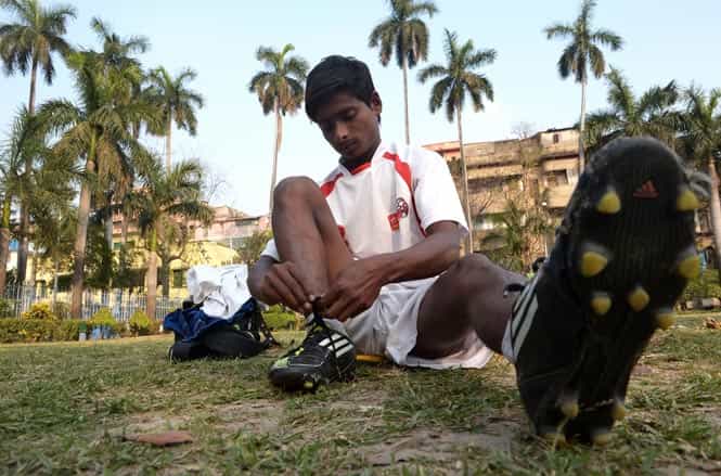 Rajib Boy ties his shoelaces as he takes part in a training session in Kolkata. (AFP Photo) Rajib Boy ties his shoelaces as he takes part in a training session in Kolkata. (AFP Photo)