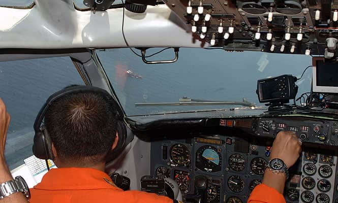 This handout photograph released by the Indonesian Air Force shows the pilot aboard an Indonesian Air Force military surveillance aircraft on March 11 over the Malacca Strait, a passageway between Indonesia and Malaysia, searching for the missing Malaysia Airlines flight MH370. (AFP Photo)</em)