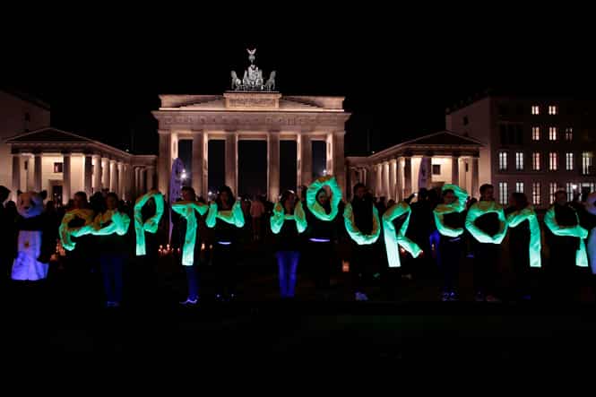 Activists of the World Wide Fund For Nature spell out the words Earth Hour 2014 in front of the illuminated Brandenburg gate before the lights were turned off to mark Earth Hour in Berlin. (AP photo)</em) Activists of the World Wide Fund For Nature spell out the words Earth Hour 2014 in front of the illuminated Brandenburg gate before the lights were turned off to mark Earth Hour in Berlin. (AP photo)</em)