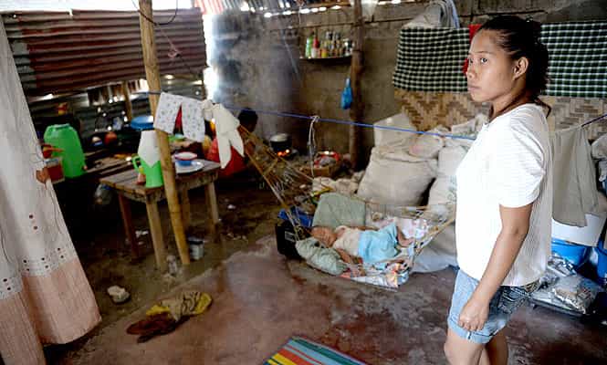 In this photo taken on February 15, 2014, Typhoon Haiyan survivor Emily Sagalis stands next to her baby inside their tent that is serving as temporary shelter. (AFP Photo) In this photo taken on February 15, 2014, Typhoon Haiyan survivor Emily Sagalis stands next to her baby inside their tent that is serving as temporary shelter. (AFP Photo)