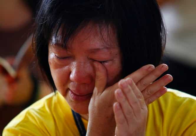 A woman cries during a special prayer session for the family members of passengers onboard the missing Malaysia Airlines flight MH370 in a Buddhist temple in Subang Jaya. (Reuters Photo)</em) A woman cries during a special prayer session for the family members of passengers onboard the missing Malaysia Airlines flight MH370 in a Buddhist temple in Subang Jaya. (Reuters Photo)</em)