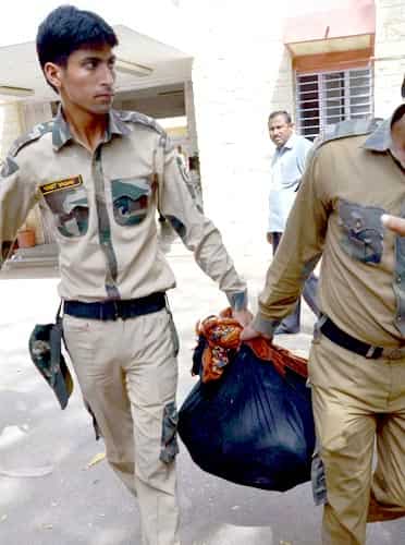 Commandos of Delhi Police carry explosives recovered from four suspects of Indian Mujahideen in Jodhpur. (PTI photo) 
</div)