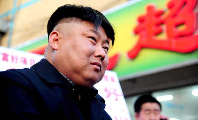 A Chinese street food vendor with a resemblance to North Korean leader Kim Jong-Un sits by his barbecue stall in Shenyang, northeast China's Liaoning province. (AFP photo)</em)