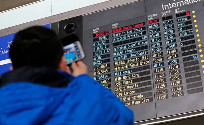 A man takes pictures of a flight information board displaying the scheduled time of arrival of Malaysia Airlines flight MH370 (top, in red) at the Beijing Airport. (Reuters photo)</strong) A man takes pictures of a flight information board displaying the scheduled time of arrival of Malaysia Airlines flight MH370 (top, in red) at the Beijing Airport. (Reuters photo)</strong)
