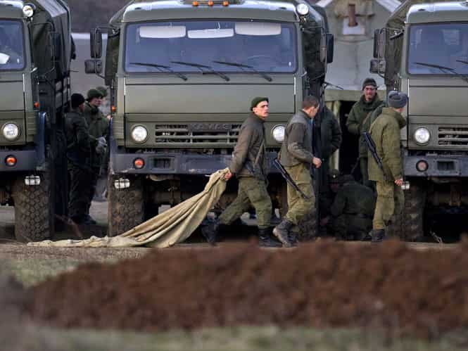 Pro-Russian soldiers walk past trucks that define the limits of their staging area in the vicinity of a Ukrainian military base in Perevalne, Ukraine. (AP photo)</strong) Pro-Russian soldiers walk past trucks that define the limits of their staging area in the vicinity of a Ukrainian military base in Perevalne, Ukraine. (AP photo)</strong)