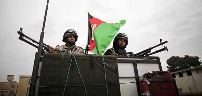 Afghan soldiers stand next to a national flag on a military vehicle while escorting trucks transporting ballot boxes and election material to polling stations in the northwestern city of Herat. (AFP photo)
</div) Afghan soldiers stand next to a national flag on a military vehicle while escorting trucks transporting ballot boxes and election material to polling stations in the northwestern city of Herat. (AFP photo)
</div)