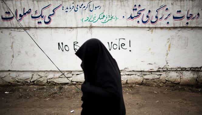 An Afghan resident walks past a graffiti slogan against the forthcoming presidential election in the northwestern city of Herat. (AFP photo)
</div) An Afghan resident walks past a graffiti slogan against the forthcoming presidential election in the northwestern city of Herat. (AFP photo)
</div)