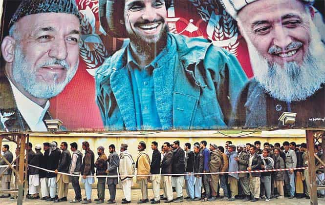 Afghan residents wishing to vote line up underneath a billboard showing images of Afghan President Hamid Karzai (L) and of deceased Afghan figures Burhandin Rabani (R) and Ahmad Shah Massoud (C) outside a polling station in Mazar-i-Sharif on Saturday. (AFP Photo) Afghan residents wishing to vote line up underneath a billboard showing images of Afghan President Hamid Karzai (L) and of deceased Afghan figures Burhandin Rabani (R) and Ahmad Shah Massoud (C) outside a polling station in Mazar-i-Sharif on Saturday. (AFP Photo)