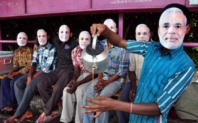 BJP workers wearing party's PM candidate Modi's mask, serve tea in Allahabad. (PTI photo)</em) BJP workers wearing party's PM candidate Modi's mask, serve tea in Allahabad. (PTI photo)</em)