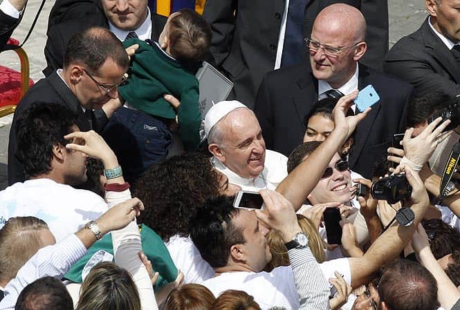 Faithful take pictures with Pope Francis at the end of the Palm Sunday Mass in St. Peter's square at the Vatican. (AP Photo) 
</div)