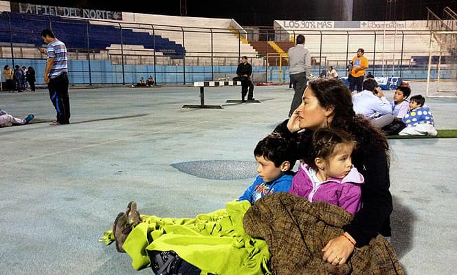Locals take refuge at the city stadium following a tsunami alert after a powerful 8.0-magnitude earthquake hit off Chile's Pacific coast in Iquique. (AFP Photo)</em) Locals take refuge at the city stadium following a tsunami alert after a powerful 8.0-magnitude earthquake hit off Chile's Pacific coast in Iquique. (AFP Photo)</em)