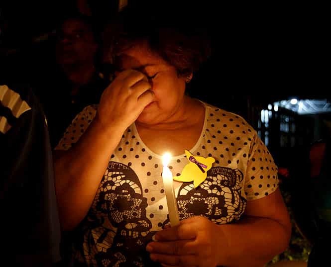 A resident holding a candle cries in front of Marquez's house in Aracataca. (Reuters photo)</em) A resident holding a candle cries in front of Marquez's house in Aracataca. (Reuters photo)</em)