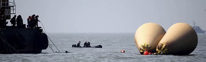 South Korean rescue workers operate near floats where the capsized passenger ship Sewol sank, during the search and rescue operation in the sea off Jindo. (Reuters Photo)</em) South Korean rescue workers operate near floats where the capsized passenger ship Sewol sank, during the search and rescue operation in the sea off Jindo. (Reuters Photo)</em)