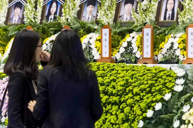 Women visit a newly opened group memorial altar for the victims from the sunken South Korean ferry "Sewol" at the Ansan Olympic memorial hall just down the street from Danwon high school where many of the schoolchildren, lost in the accident, attended. (AFP Photo)</em) Women visit a newly opened group memorial altar for the victims from the sunken South Korean ferry "Sewol" at the Ansan Olympic memorial hall just down the street from Danwon high school where many of the schoolchildren, lost in the accident, attended. (AFP Photo)</em)