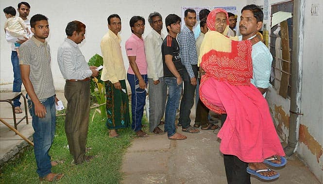 A woman is carried by her son after she casted her vote at a polling station in Jaipur. Photo by PTI A woman is carried by her son after she casted her vote at a polling station in Jaipur. Photo by PTI
