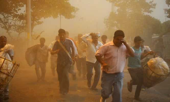 People run to take shelter near Connaught Place as a massive dust storm and rains strike in New Delhi. (Saumya Khandelwal/HT photo) 
</div)