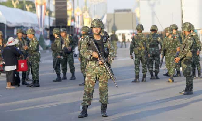 Armed Thai soldiers take their positions inside an encampment of pro-government "red shirt" supporters in Nakhon Pathom province on the outskirts of Bangkok. Thailand's army chief General Prayuth Chan-ocha took control of the government in the coup saying the army had to restore order and push through reforms, two days after he declared martial law. (Reuters Photo)</em) Armed Thai soldiers take their positions inside an encampment of pro-government "red shirt" supporters in Nakhon Pathom province on the outskirts of Bangkok. Thailand's army chief General Prayuth Chan-ocha took control of the government in the coup saying the army had to restore order and push through reforms, two days after he declared martial law. (Reuters Photo)</em)