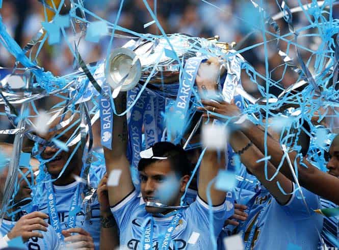 Manchester City's Sergio Aguero celebrates with the English Premier League trophy following their soccer match against West Ham United at the Etihad Stadium in Manchester, northern England. (Reuters) </em) Manchester City's Sergio Aguero celebrates with the English Premier League trophy following their soccer match against West Ham United at the Etihad Stadium in Manchester, northern England. (Reuters) </em)