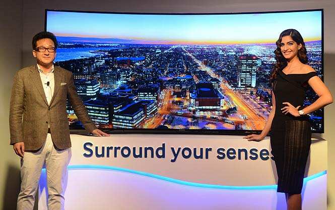 Bollywood actress Sonam Kapoor and Managing Director Samsung India, S.K. Kim unveil the Samsung Curved TV range in New Delhi. (AFP Photo)</em)