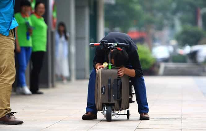 A man checks He Liangcai's scooter. (AFP Photo)</em>
</div) A man checks He Liangcai's scooter. (AFP Photo)</em>
</div)