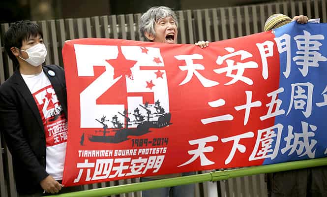 A protester holds a banner in front of the Chinese Embassy in Tokyo. A group of protesters staged a rally to mark the 25th anniversary of the Chinese military crackdown on the pro-democracy movement in Beijing's Tiananmen Square. (AP Photo)</em)