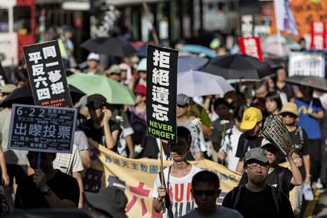 Protesters hold placards during a march for democracy in China, in Hong Kong. Protesters took to the streets in protest ahead of the 25th anniversary of the 1989 Tiananmen Square crackdown. (EPA photo) 
</div)