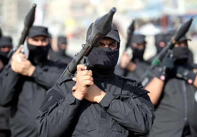 Iraqi Shiite fighters parade with their weapons in Baghdad. (AFP Photo)</em) Iraqi Shiite fighters parade with their weapons in Baghdad. (AFP Photo)</em)
