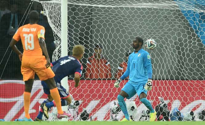 Japan's forward Keisuke Honda (C) shoots and scores past Ivory Coast's goalkeeper Boubacar Barry during their World Cup match at the Pernambuco Arena in Recife. (AFP Photo)
</div) Japan's forward Keisuke Honda (C) shoots and scores past Ivory Coast's goalkeeper Boubacar Barry during their World Cup match at the Pernambuco Arena in Recife. (AFP Photo)
</div)