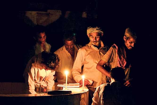 A boy uses a hand fan to comfort a patient during electricity outage at Swaroop Rani Nehru Hospital on a hot summer day in Allahabad. (PTI Photo)</em> 
</div)
