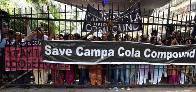 Campa Cola residents block the entrance for the BMC officials who arrived to disconnect the water and electricity supply of the society, in Mumbai. (PTI Photo)</em)