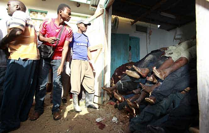 Residents look at slain slain bodies of people killed when unidentified gunmen attacked the coastal Kenyan town of Mpeketoni. (Reuters Photo)</em) Residents look at slain slain bodies of people killed when unidentified gunmen attacked the coastal Kenyan town of Mpeketoni. (Reuters Photo)</em)