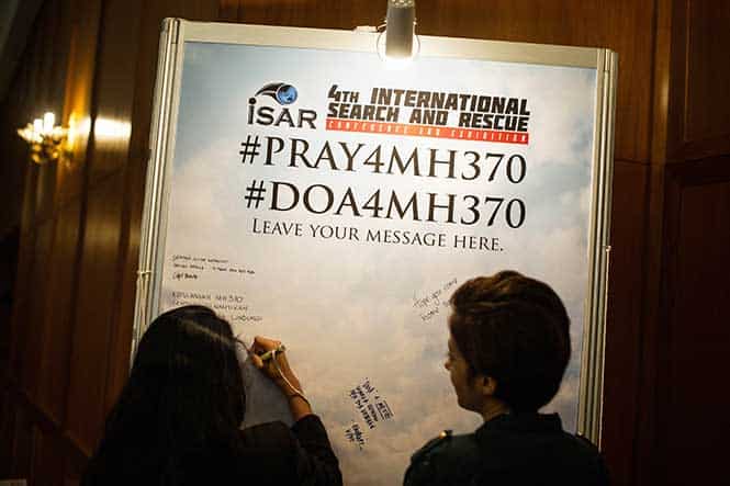 A visitor writes on a placard carrying messages for the passengers of missing Malaysia Airlines flight MH370 during the 4th International Search and Rescue Conference and Exhibition (ISAR) in Kuala Lumpur. (AFP Photo)</em) A visitor writes on a placard carrying messages for the passengers of missing Malaysia Airlines flight MH370 during the 4th International Search and Rescue Conference and Exhibition (ISAR) in Kuala Lumpur. (AFP Photo)</em)