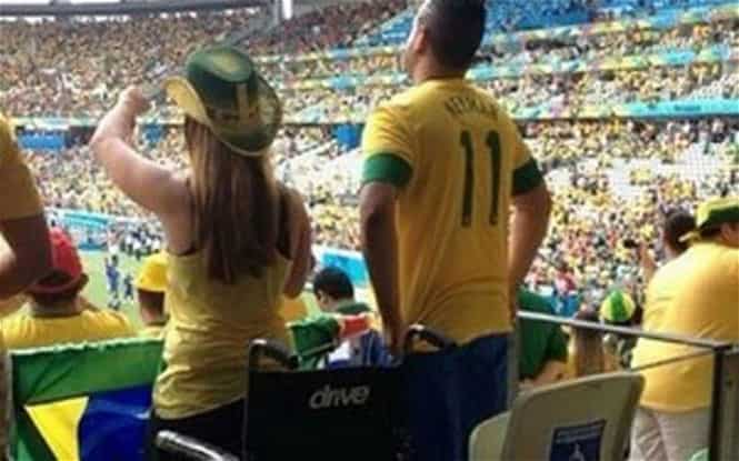 A picture of a Brazilian fan standing in front of her wheelchair and clapping at a World Cup stadium has sparked controversy over the alleged "miracle" (Photo: Twitter)
</div) A picture of a Brazilian fan standing in front of her wheelchair and clapping at a World Cup stadium has sparked controversy over the alleged "miracle" (Photo: Twitter)
</div)