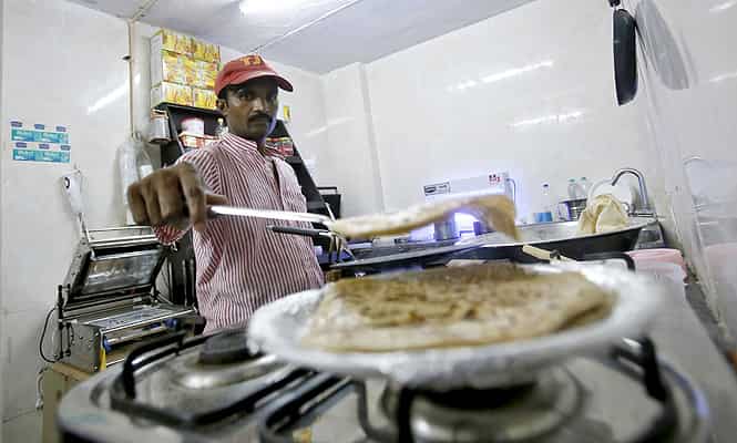 An inmate prepares food inside the kitchen of a restaurant run by the Tihar Jail authorities on Jail Road in west Delhi. (Reuters photo) 
</div)