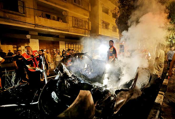 Smoke rises from a vehicle, destroyed by an Israeli strike, after Palestinian fire fighters put out the fire, in Gaza City. (AP photo)</em>
</div) Smoke rises from a vehicle, destroyed by an Israeli strike, after Palestinian fire fighters put out the fire, in Gaza City. (AP photo)</em>
</div)
