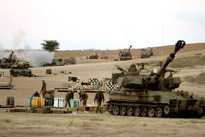 Israeli soldiers of the 155mm artillery cannons unit fire towards the Gaza Strip from their position near Israel's border with the coastal Palestinian enclave. (AFP photo)</em>
</div) Israeli soldiers of the 155mm artillery cannons unit fire towards the Gaza Strip from their position near Israel's border with the coastal Palestinian enclave. (AFP photo)</em>
</div)