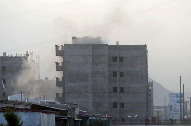 Smoke rises from the building at the site of a suicide attack in front of Kabul's military airport. (AFP Photo)</em) Smoke rises from the building at the site of a suicide attack in front of Kabul's military airport. (AFP Photo)</em)