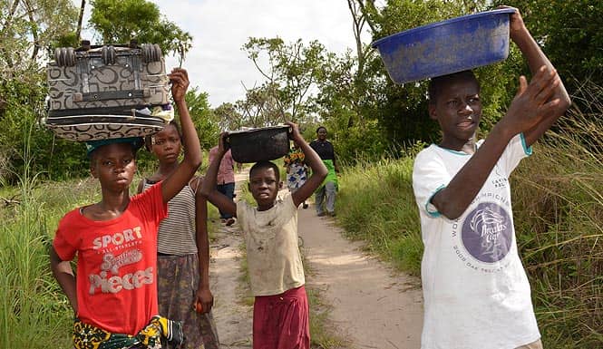Children from Kenya's coastal Lamu region flee their home with their belongings following a new attack in Lamu. (AFP photo)
</div) Children from Kenya's coastal Lamu region flee their home with their belongings following a new attack in Lamu. (AFP photo)
</div)