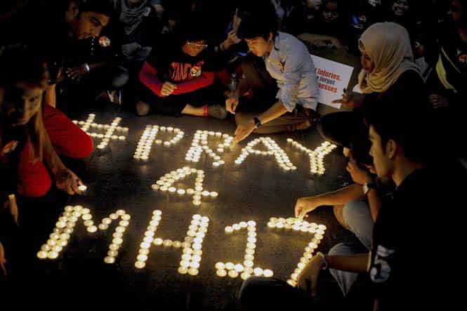 People arrange candles to offer prayers for the victims of the Malaysia Airlines Flight 17, at a shopping mall in Petaling Jaya, near Kuala Lumpur, Malaysia. (AP photo)</em>
</div) People arrange candles to offer prayers for the victims of the Malaysia Airlines Flight 17, at a shopping mall in Petaling Jaya, near Kuala Lumpur, Malaysia. (AP photo)</em>
</div)