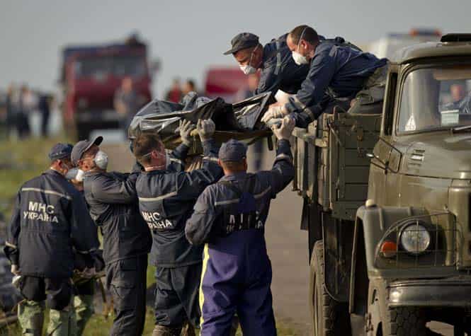 Emergency workers load the body of a victim on a truck at the crash site of Malaysia Airlines Flight 17 near the village of Hrabove, eastern Ukraine. (AP photo)</em>
</div) Emergency workers load the body of a victim on a truck at the crash site of Malaysia Airlines Flight 17 near the village of Hrabove, eastern Ukraine. (AP photo)</em>
</div)