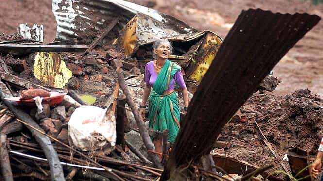 An elderly woman cries as she searches for surviving family members in the debris of her home, destroyed by landslide in Malin village, in Maharashtra. (AP photo/PTI photo) 
</div)